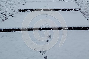 Footprints on the snow-covered steps of the park on a winter day, top view-the concept of pleasant winter walks