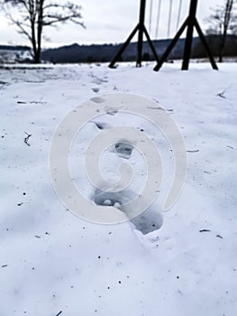 Footprints in the snow on an empty playground in winter in Bavaria, Germany