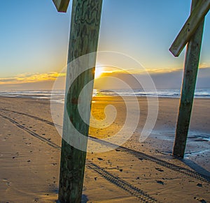 Footprints and Tracks at Sunrise on the Beach