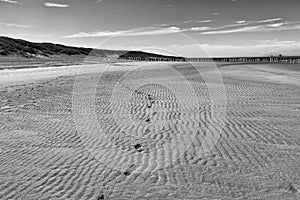 Footprints in the wet rippled sand on a beach in France