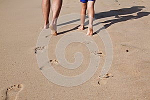 Footprints in wet sand of father and son
