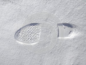 Footprints of a woman`s boot in the snow. A clear imprint of the pattern of the sole of the boots on a snowy field