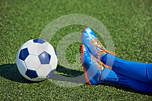 Foots boy soccer in football boots with ball on grass