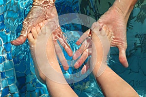 Foots of the child in palms of mother