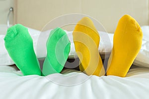 Foots of family with color sock on the bed