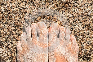 Foots on a rock with sand