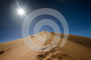 Footsteps on the top of the sand dune