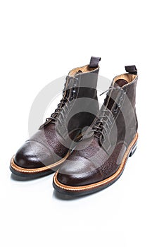 Footwear Ideas. Pair of Premium Dark Brown Grain Brogue Derby Boots Made of Calf Leather with Rubber Sole Placed in Line Together