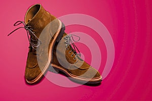 Footwear Ideas. Pair of Tan Brown Suede Split Toe High Boots Closeup With Rubber Sole Placed on One Another Over Pink Red