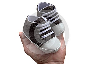 Footwear for the smallest children. Slippers for babies in hand. Children`s shoes of small size, isolated on white