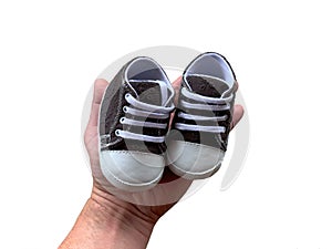 Footwear for the smallest children. Slippers for babies in hand. Children`s shoes of small size, isolated on white