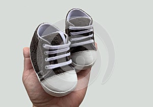 Footwear for the smallest children. Slippers for babies in hand. Children`s shoes of small size,  on white