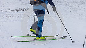 Footwork detail of a person performing a 180 degree turn while ski touring or mountaineering. Person making a turn on skis walking