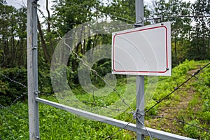 Forbidden area fenced with a barbed wire fence. Gate with padlock closed to the key. Border of States