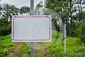 Forbidden area fenced with a barbed wire fence. Gate with padlock closed to the key. Border of States