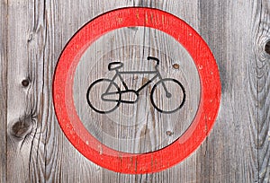 A forbidding sign for bicycles. Wood as a background. Texture of natural wood.