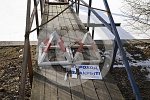 Forbidding signs and a board in Russian `passage is prohibited` at the entrance to the bridge