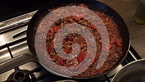Forcemeat with pepper and onion on a frying pan