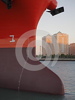 Fore of cargo vessel, houses in background