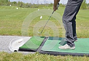 Fore - a golfer hits a tee shot at a practive range