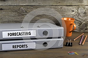 Forecasting and Reports - two folders on wooden office desk