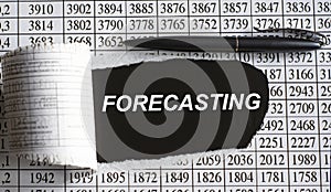 FORECASTING is the word behind torn office paper with numbers and a black pen