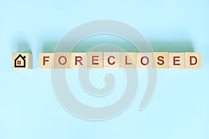 Foreclosed property concept in real estate. Wooden blocks typography