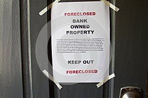 Foreclosed property notice taped on  a house door property photo