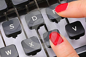 forefingers of the hand with red nail polish of an office secretary typing the key photo