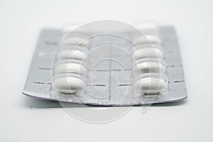 Forefront of a white circle medicine pills in blister pack isolated on white
