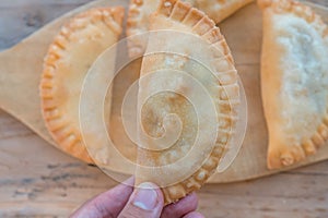 A foreground of Argentinean empanadas a background of rustic wood photo