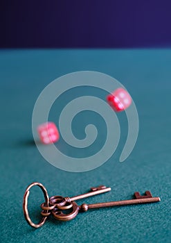 In the foreground is bunch of of house keys. Red dices and leather cup, cards on blue baize. Money loss, gambling addiction, bad