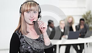 Foreground is a successful woman employee of a call center