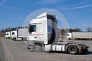 In the foreground a tractor without a semi-trailer. Parked trucks