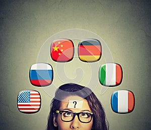 Foreign language studying process. Woman with question mark icons of international flags above head