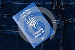 Foreign passport of a citizen of Ukraine on a dark denim background. Concept of refugees during war.