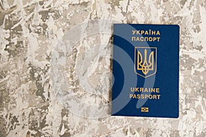 Foreign passport of a citizen of Ukraine on gray background. Concept of the departure of Ukrainians abroad or the stay