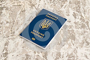 Foreign passport of a citizen of Ukraine on gray background. Concept of the departure of Ukrainians abroad or the stay