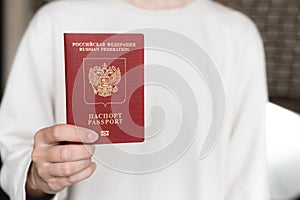 Foreign passport of the Russian Federation. Human female hand with a Russian passport close-up on the background of a