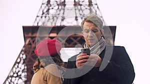 Foreign tourists watching online map on smartphone searching for sights in Paris
