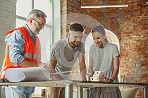 Foreman or achitect shows house, office or store design plans to a young couple photo