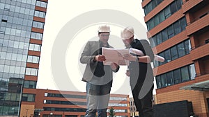 Foreman and architect at construction site. two men in construction helmets on the building location to discuss the plan