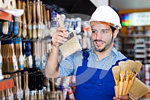 foreman in blue overalls choosing brushes