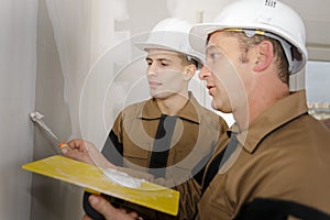 Foreman builder and construction worker working indoor