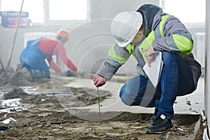 Foreman builder inspecting concrete construction work in apartment
