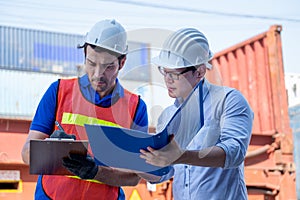 Foreman and cargo container worker discuss together with document in workplace area. Concept of good management system and
