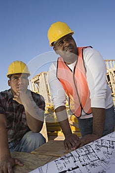 Foreman With Co-Worker Looking At Framework