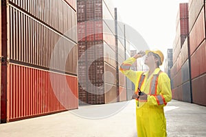 foreman control loading containers box from cargo freight ship working at dock site