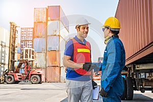 Foreman and dock worker staff shaking hand for sucess working at Container cargo harbor. Business Logistics import export shipping