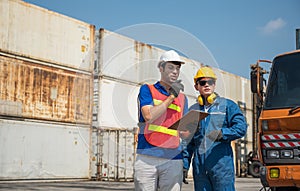 Foreman and dock worker staff working checking at Container cargo harbor holding clipboard. Business Logistics import export
